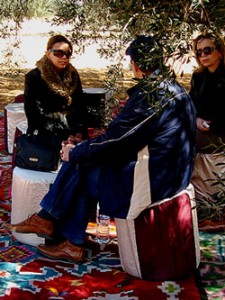  Tuffet-bound friends upon Berber carpets, huddle in the chill under an olive tree. (Photo: Tagami)