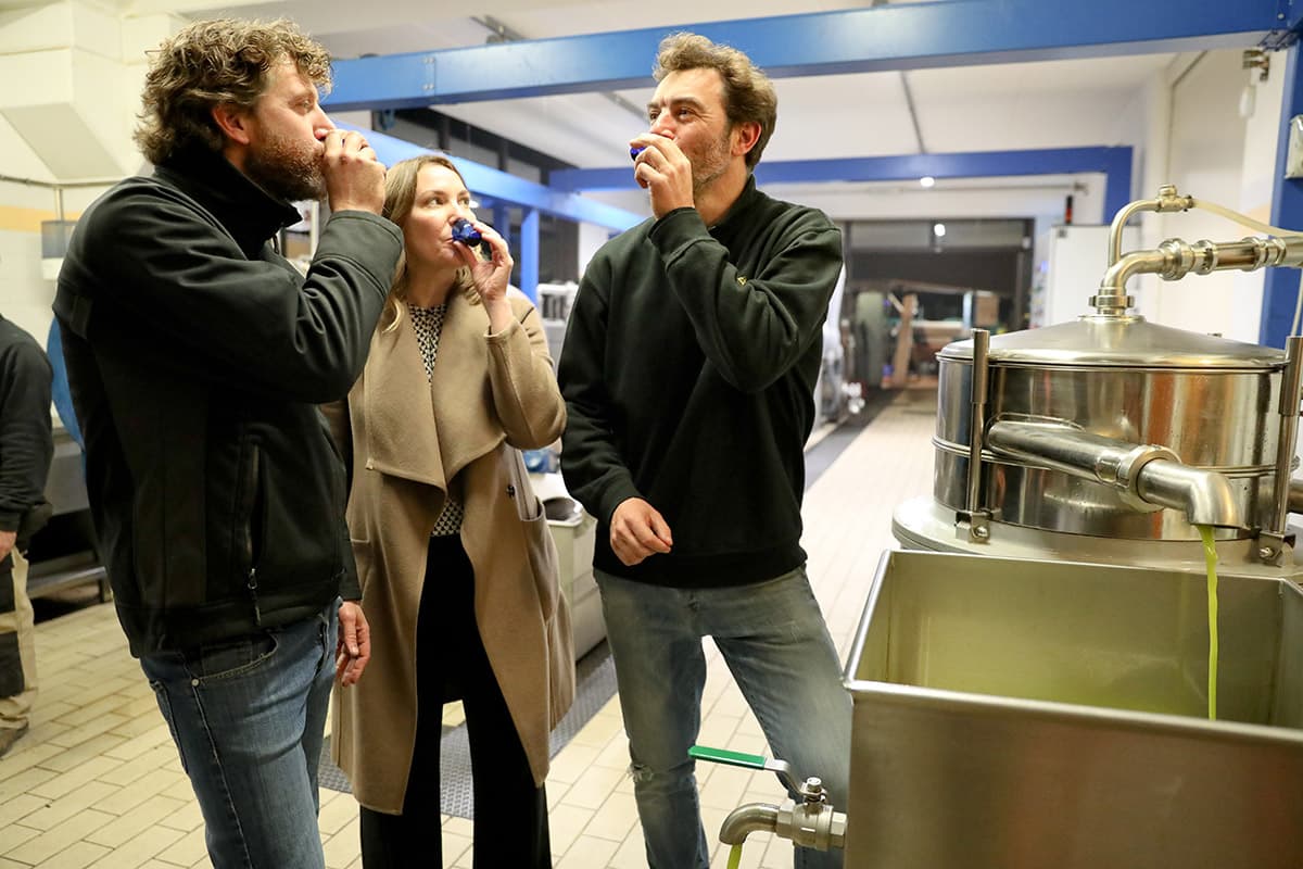 Lacina samples freshly-milled extra virgin olive oil with the award-winning Pruneti brothers in Tuscany. (Photo: Joanne Lacina)