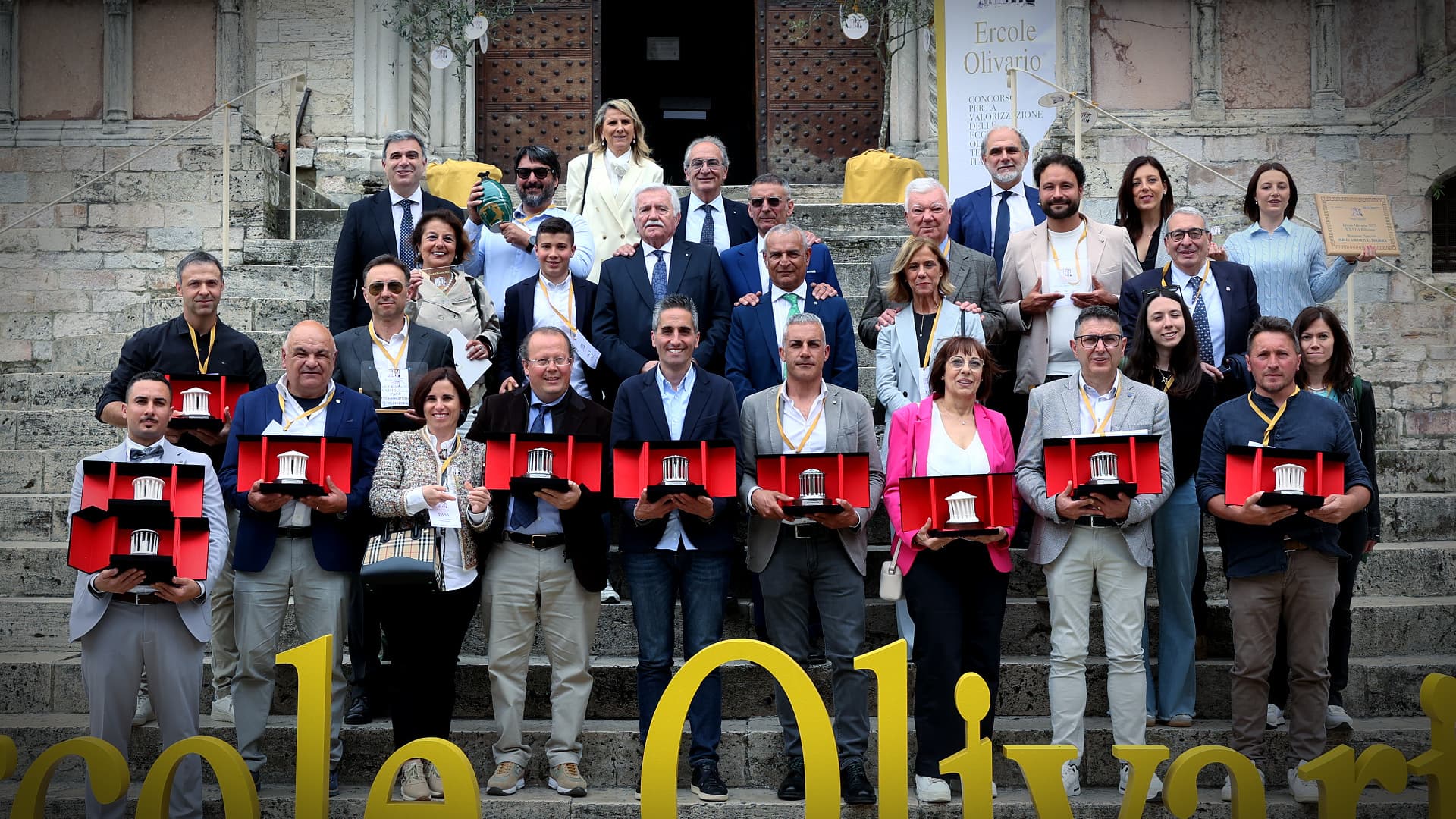 Winners of the 33rd Ercole Olivario with Federico Sisti, secretary-general, and Giorgio Mencaroni, president of the Umbria Chamber of Commerce, in front of the Palazzo dei Priori in Perugia, Umbria. (Photo: Ercole Olivario)