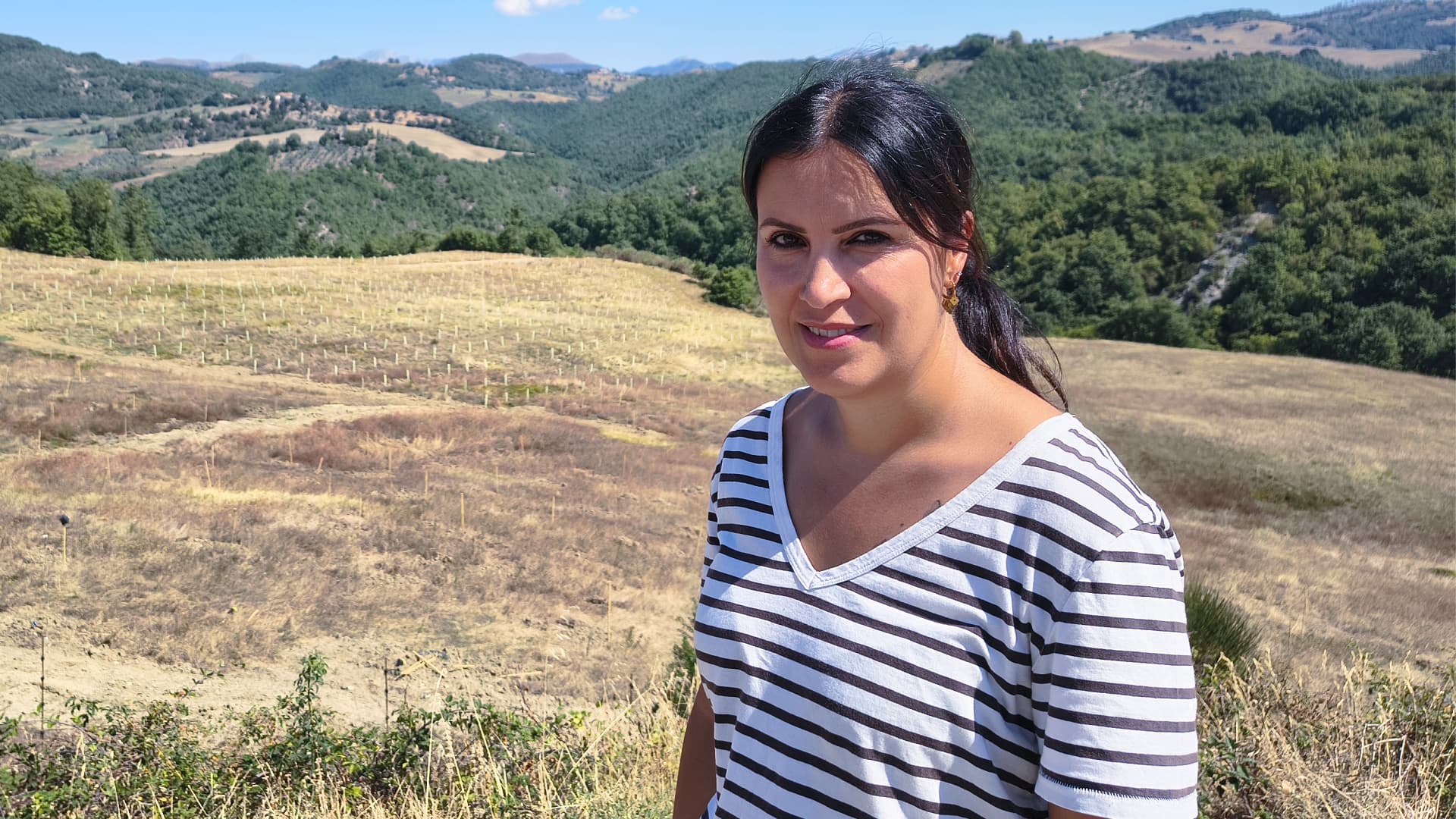 Soraya Mousavi, scientific director of Domus Olear∑ in Gubbio, stands before young olive trees in the collection managed by the Institute of Biosciences and Bioresources (CNR-IBBR).